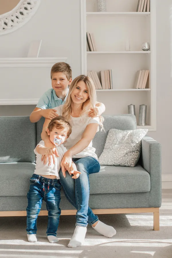 Leena as a mom – Life behind the blog Leena sitting on the couch with her two young sons, showing the balance between motherhood and blogging.